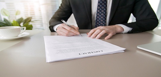 Close up of male hand putting signature in contract, businessman signing document. Successful negotiation concept, agreeing to terms, bound by contract, intend to enter in agreement, feeling confident